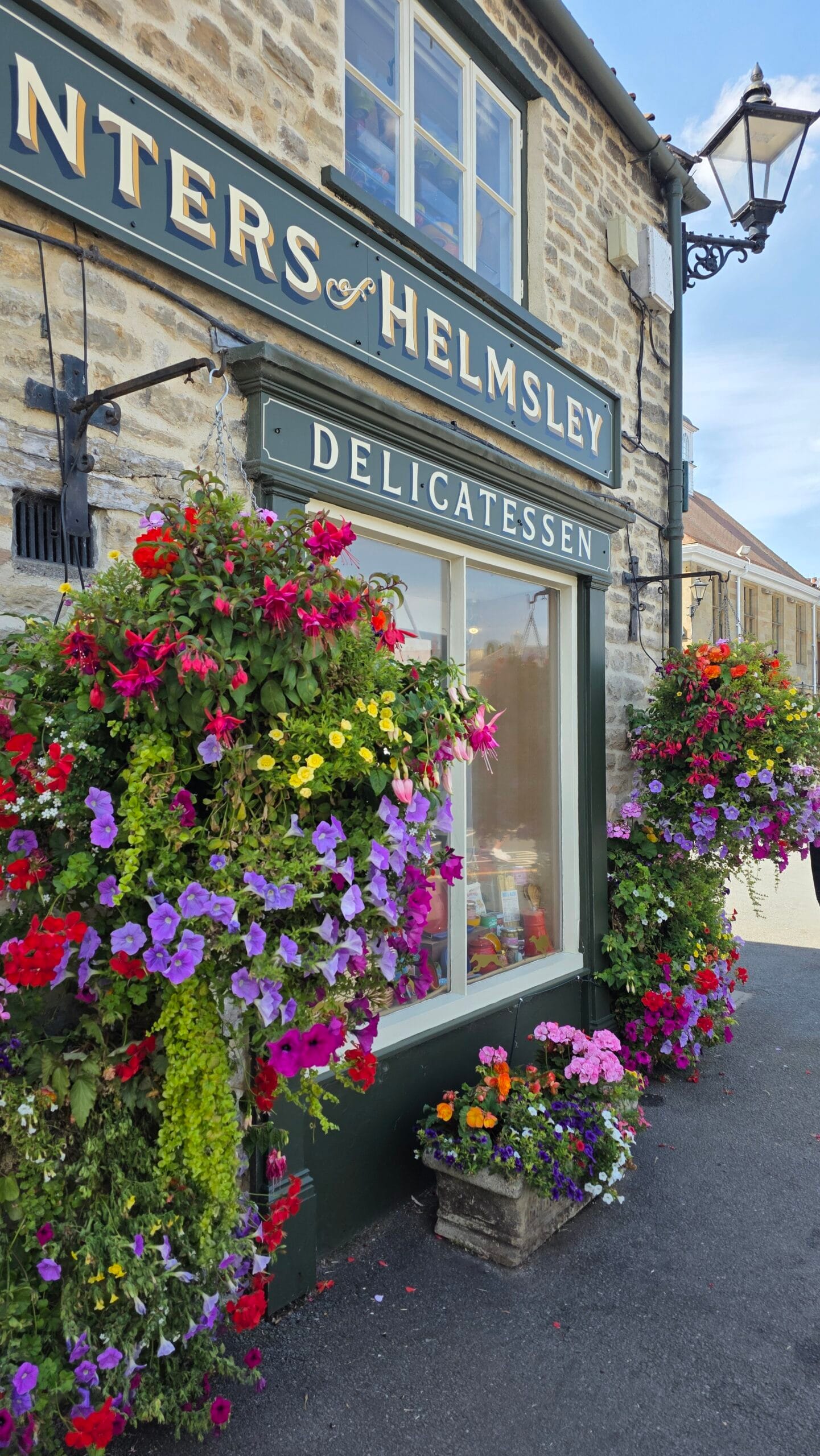 Best Day Trips From York Without a Car Helmsley delicatessen with colourful hanging flower baskets
